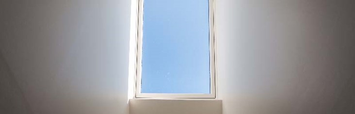 Blick aus dem Fenster in den blauen Himmel